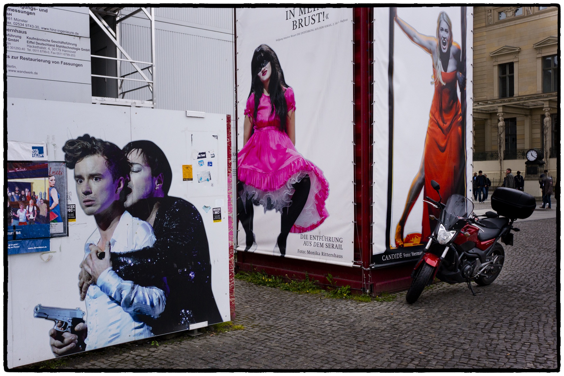 Teateraffischer i starka färger med motorcykel parkerad framför