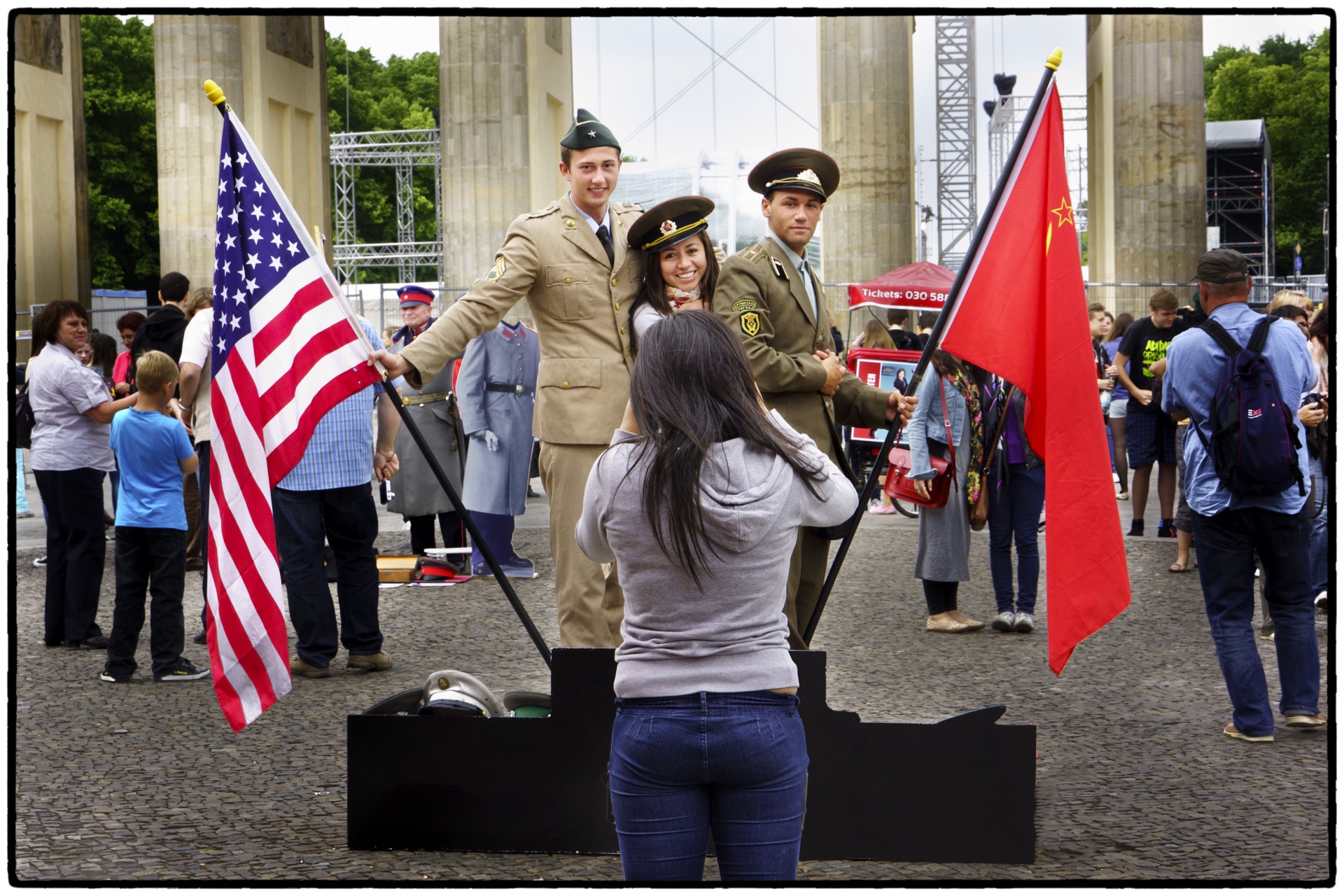 Turister poserar med soldater och flaggor vid Brandenburger Tor