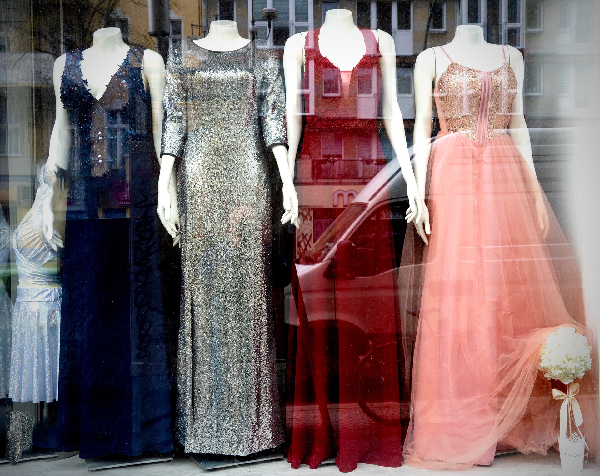 Skyltdockor med svarta leggings och rosa klänning, reflektioner i fönstret