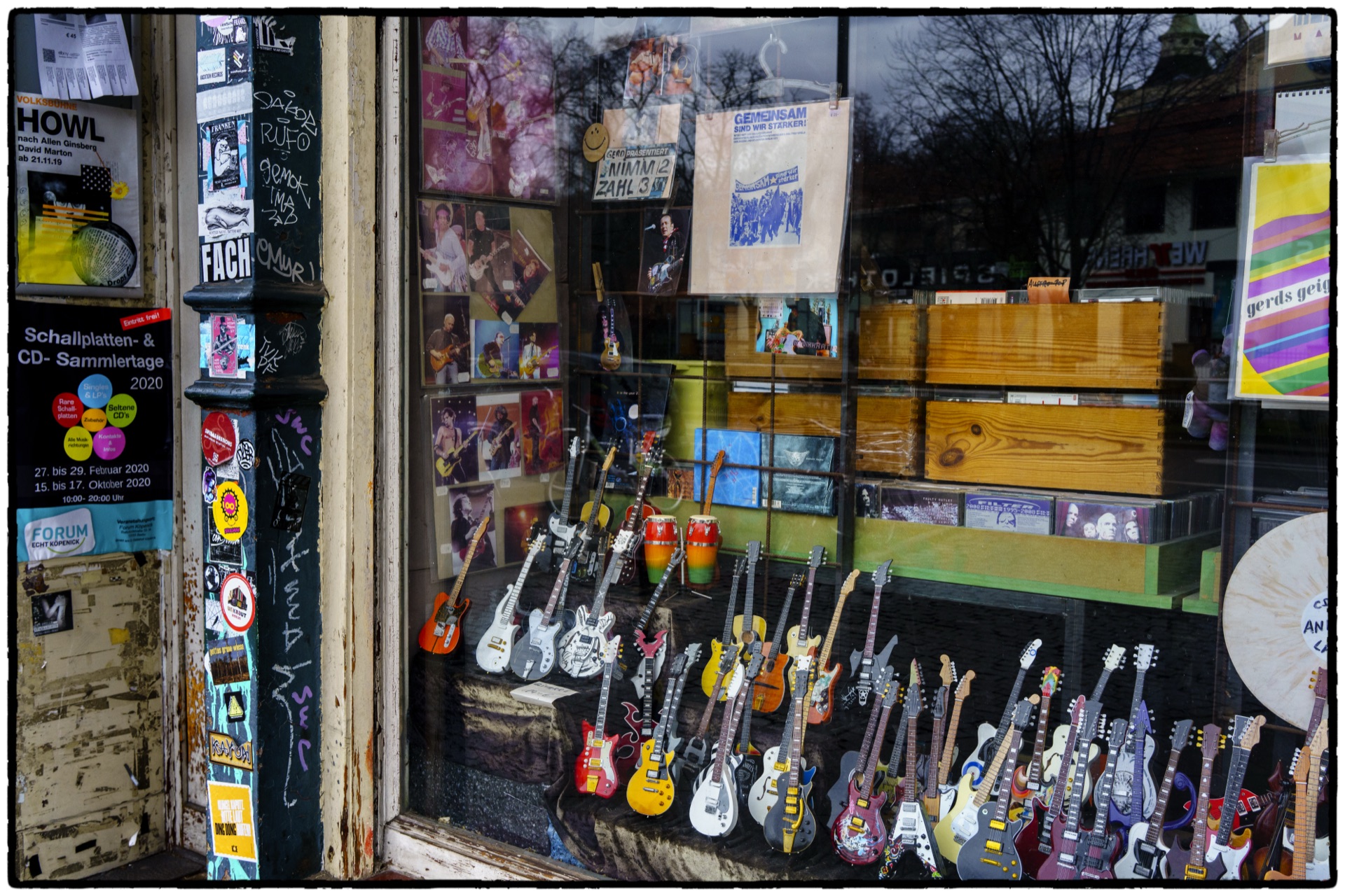 Skyltfönster med miniatyrgitarrer och skivor i sliten butik