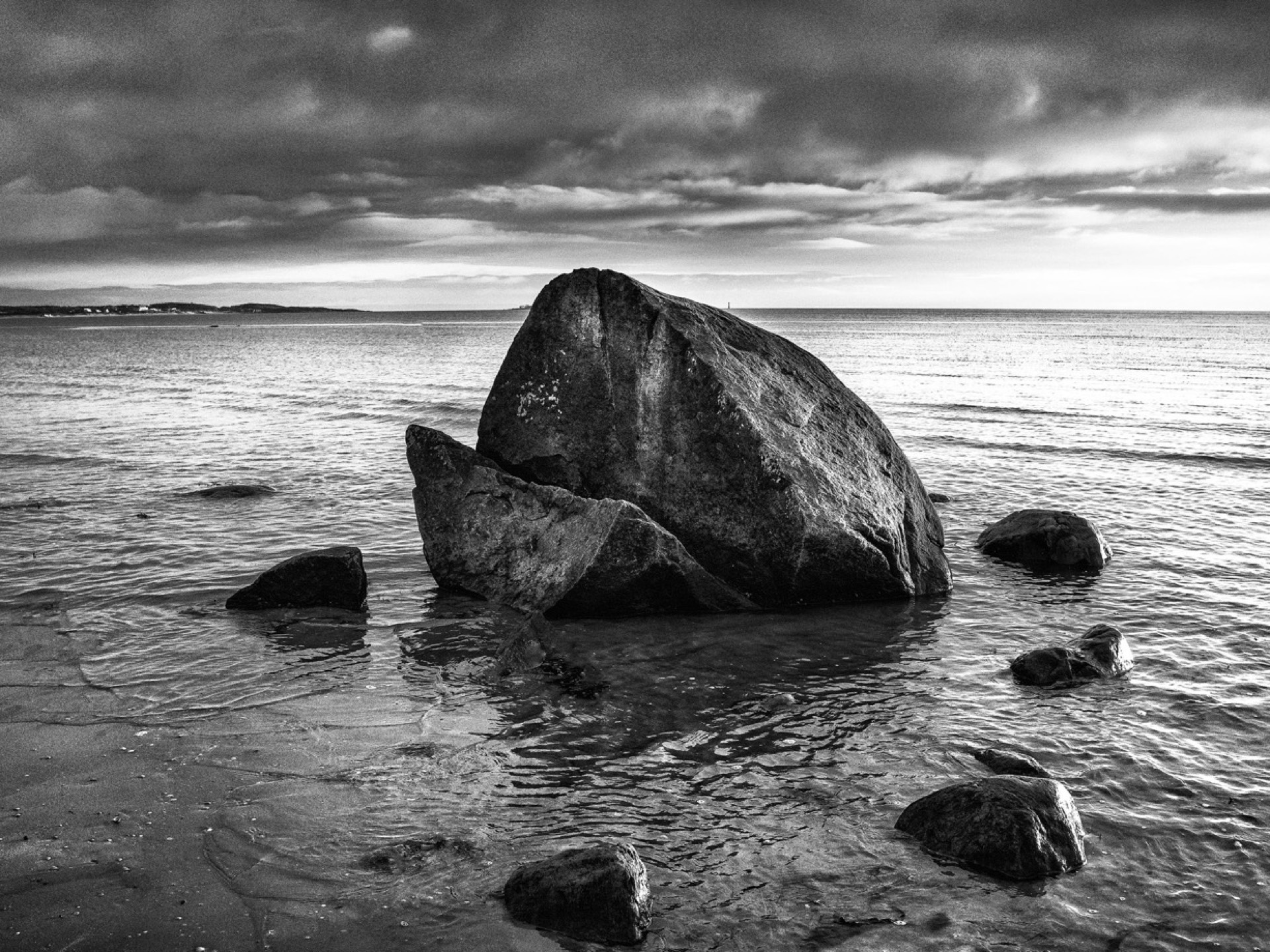 Stort stenblock i havet med dramatisk himmel