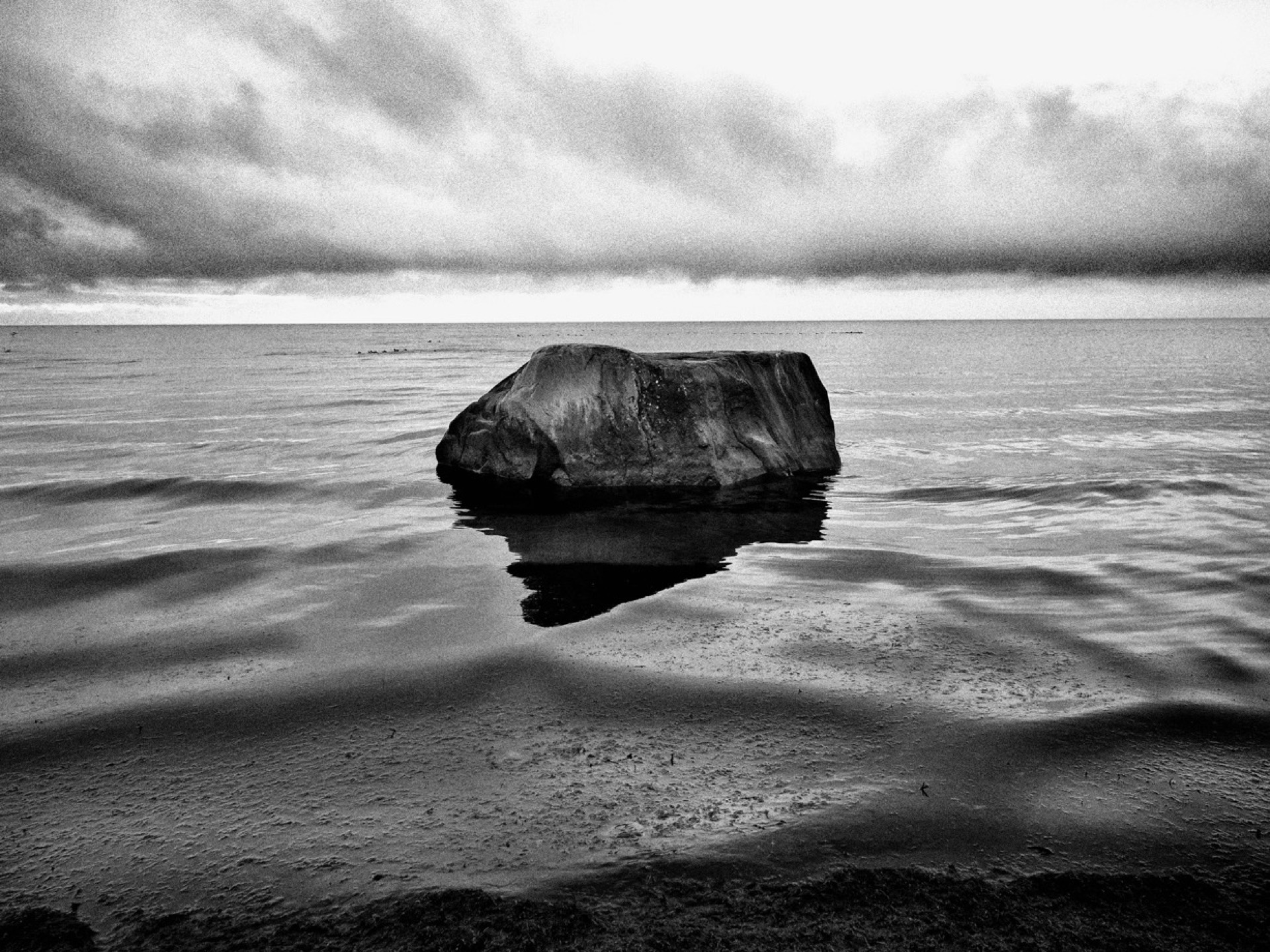 Stenblock i vatten med reflektion