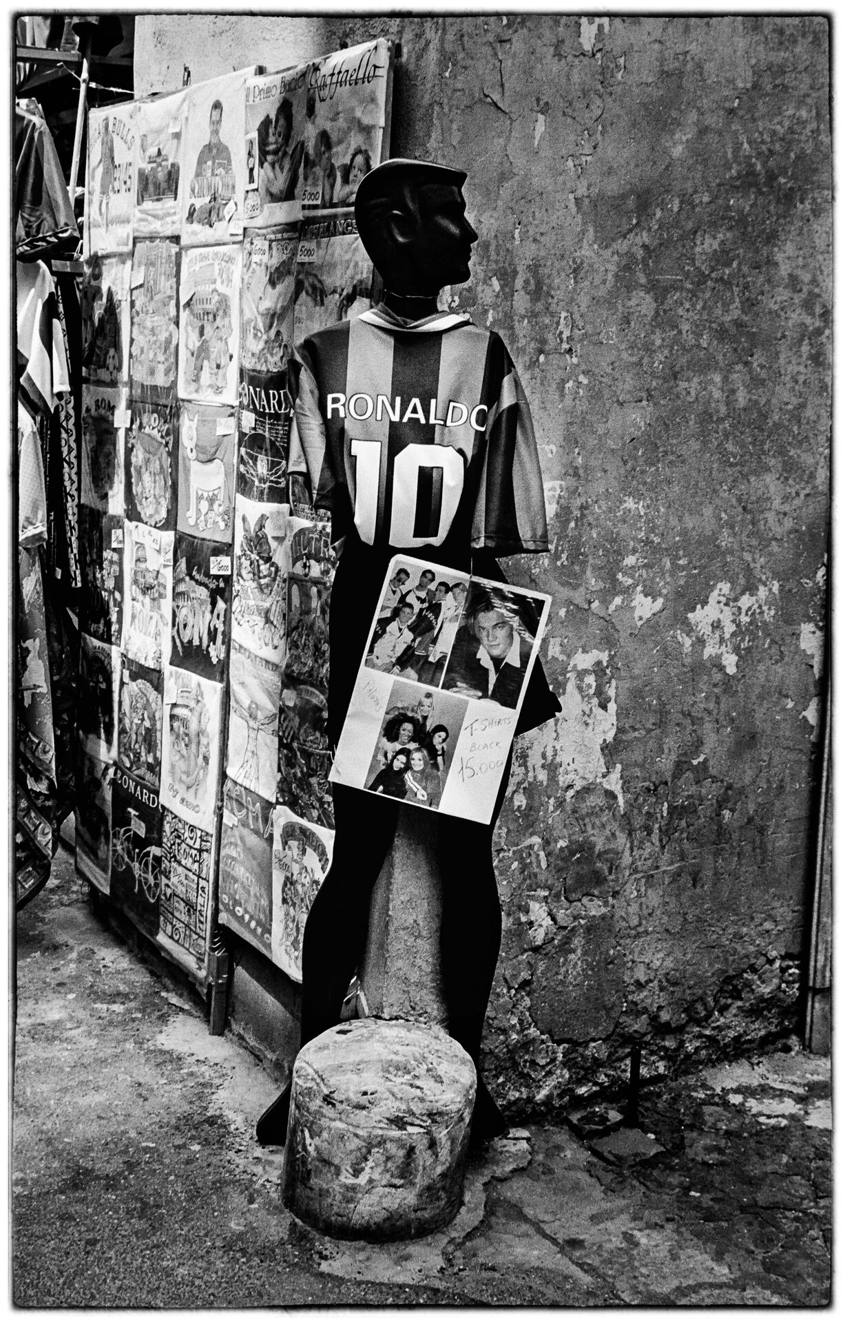 Provdocka i Ronaldo-tröja bland tavlor och affischer vid gatuhörn