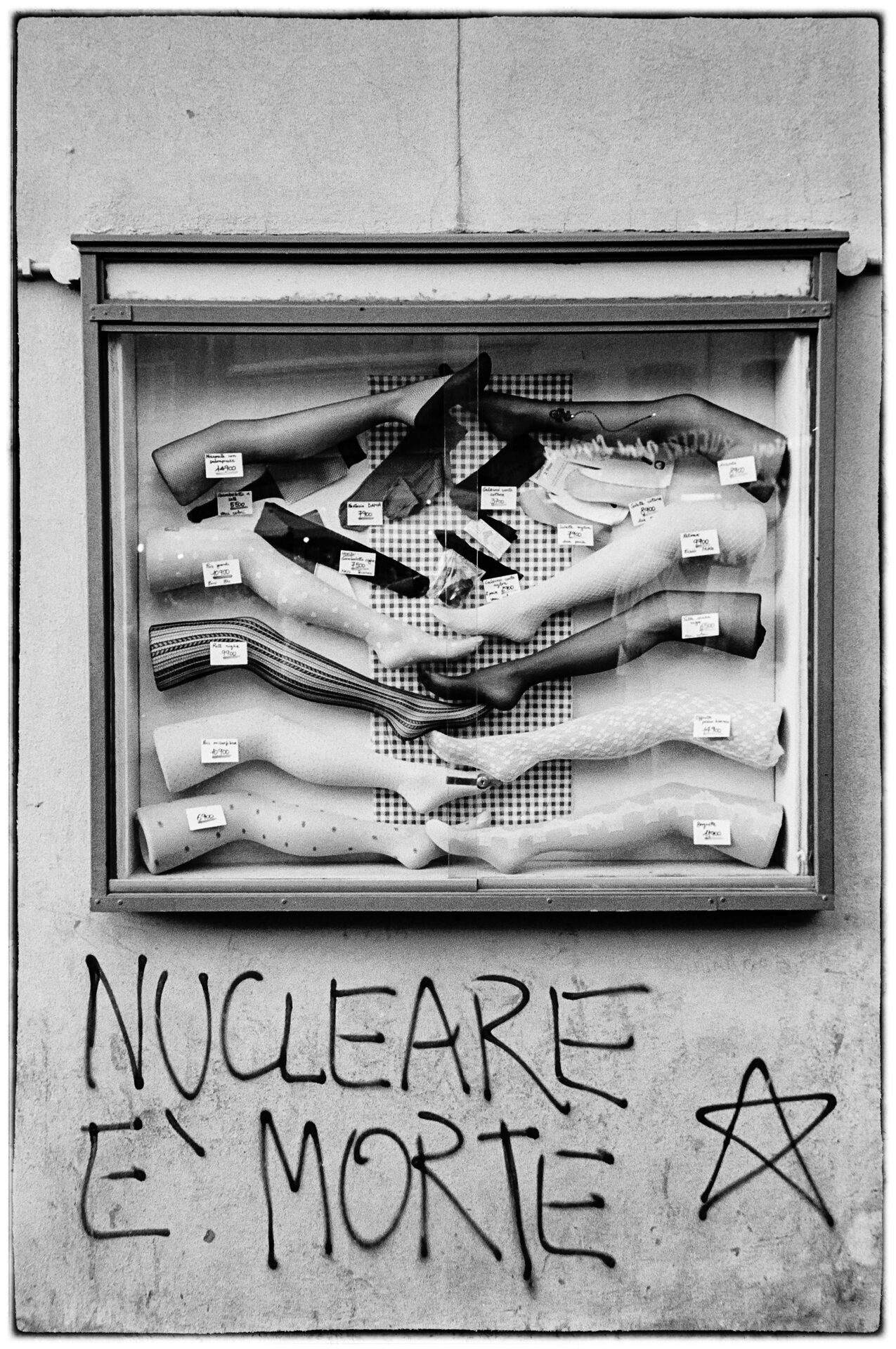 Skyltfönster med skyltdockor och klottret Nucleare è Morte