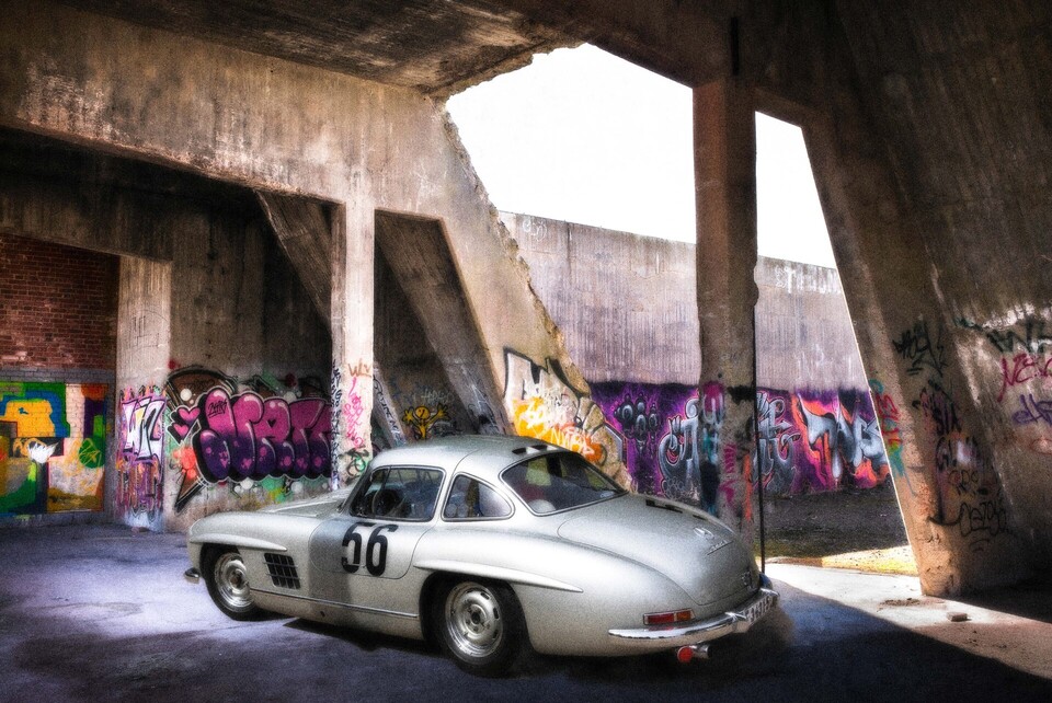 En silverf&auml;rgad Mercedes 300 SL Gullwing parkerad i en graffitim&aring;lad betongruin