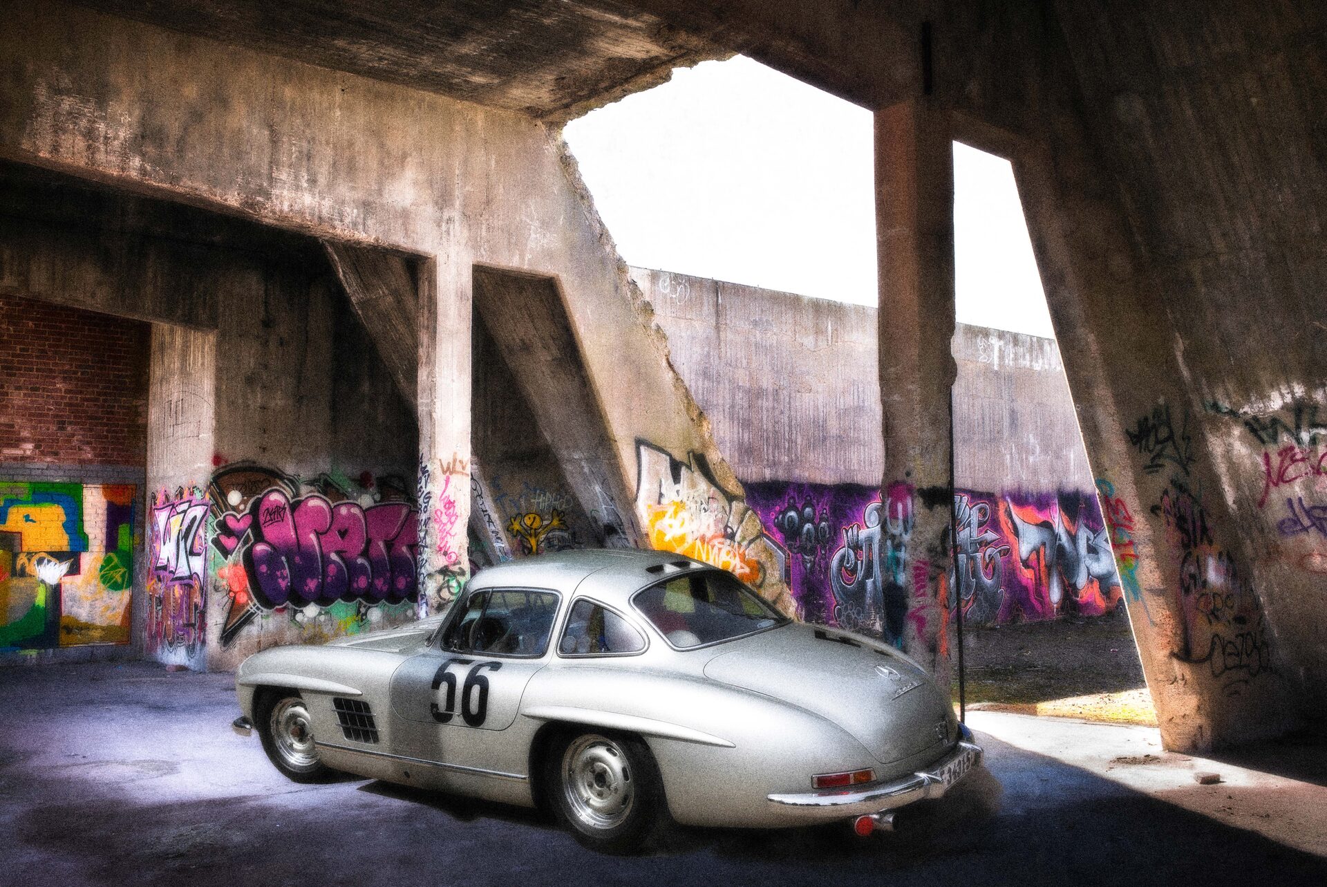 Silver Mercedes 300SL Gullwing under betongpelare med graffiti